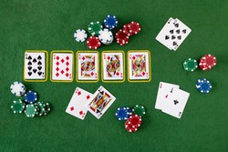 A poker game in progress on a green table, showing community cards (8 of spades, 10 of diamonds, 5 of hearts, king of hearts, king of spades), poker chips, and two sets of hole cards held by players.